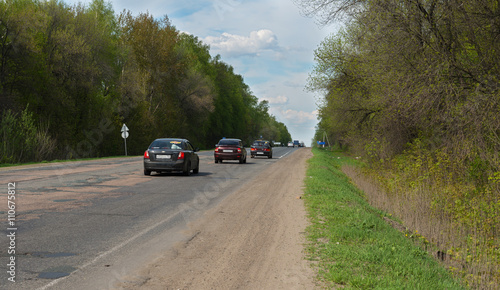 cars on the road in a wooded area