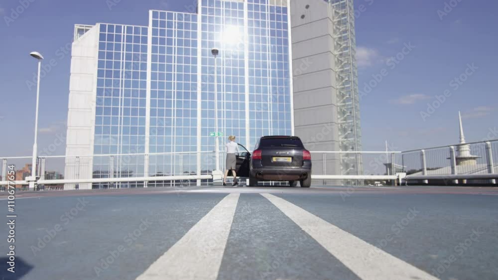  Beautiful businesswoman traveling - taking luggage out of car in car park
