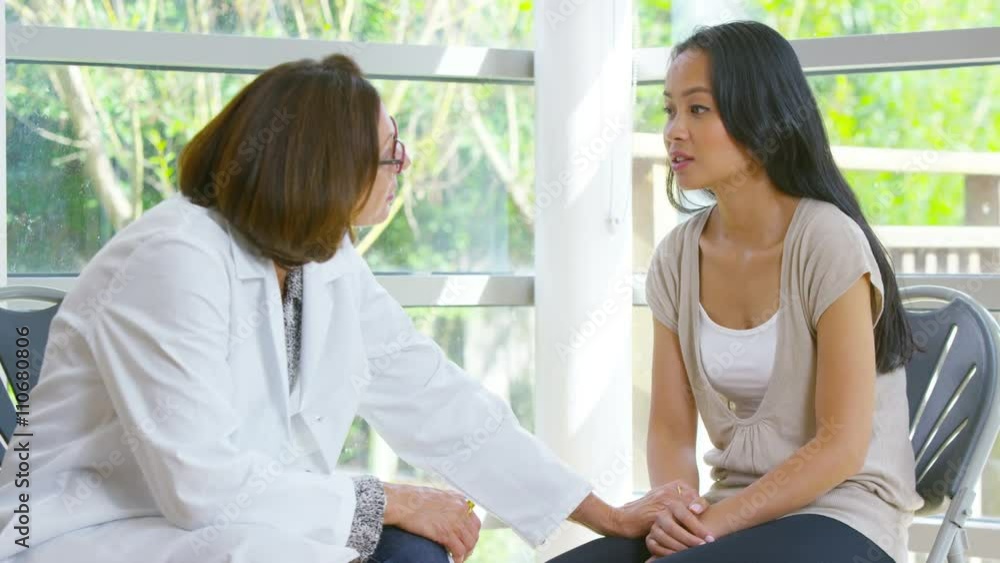 Worried woman sits alone in hospital waiting area Worried woman sits alone in hospital waiting area