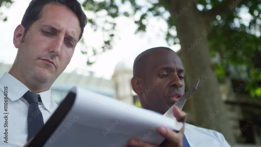 City businessmen having outdoor meeting with papers and computer tablet City businessmen having outdoor meeting with papers and computer tablet