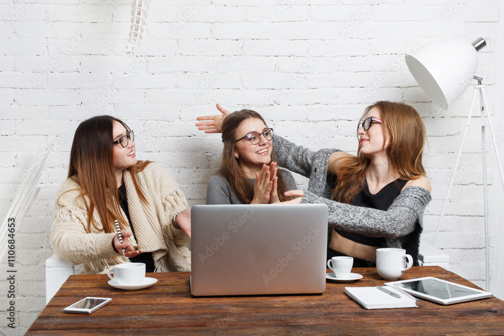 Portrait of three laughing girlfriends with laptop. Portrait of three laughing girlfriends with laptop.