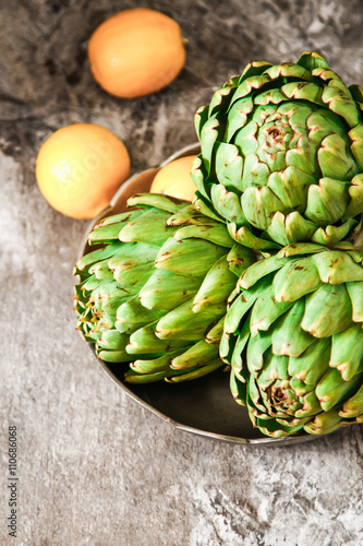 fresh artichokes on rustic wooden background