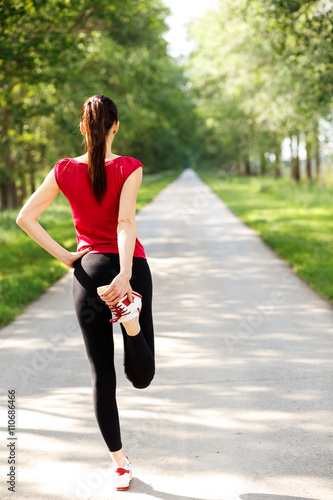 Young sportswoman stretching and preparing to run.