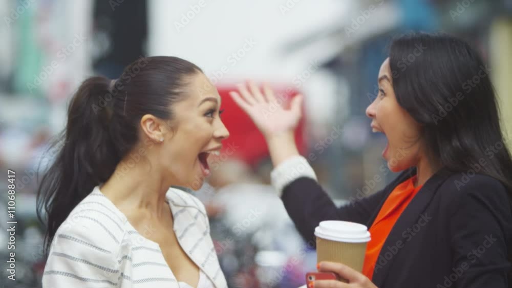 Beautiful female friends chatting & having fun outdoors in the city Beautiful female friends chatting & having fun outdoors in the city