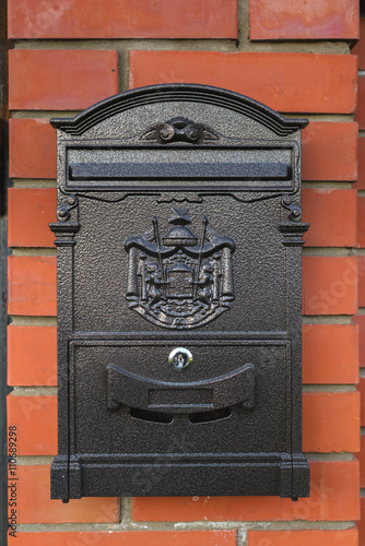 Black mailbox on a brick wall