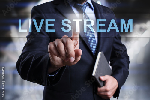 Businessman is pressin on virtual screen and selecting "Live Stream"