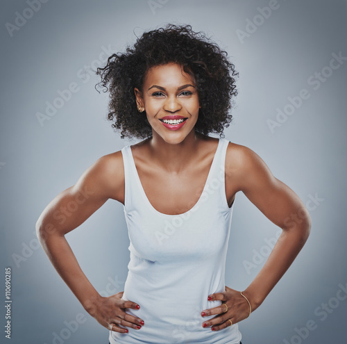 Happy female leaning forward with hands on hips