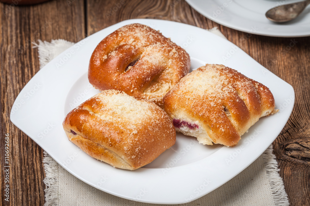 Buns with berries on a wooden table. Buns with berries on a wooden table.