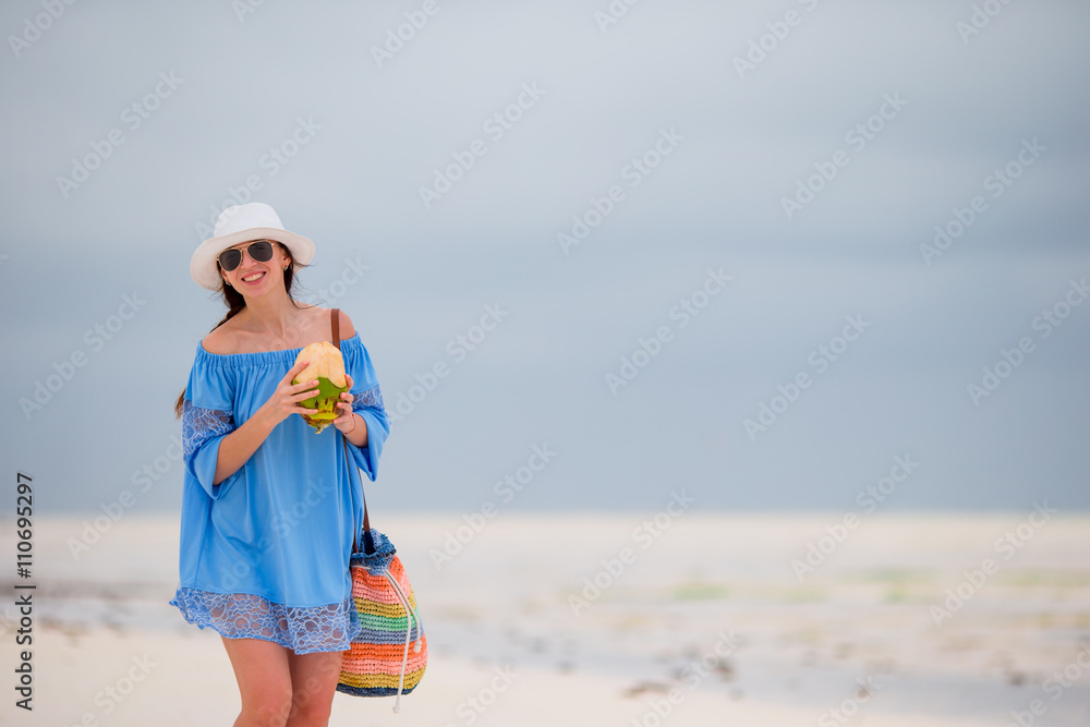 Young woman drinking coconut milk on the beach