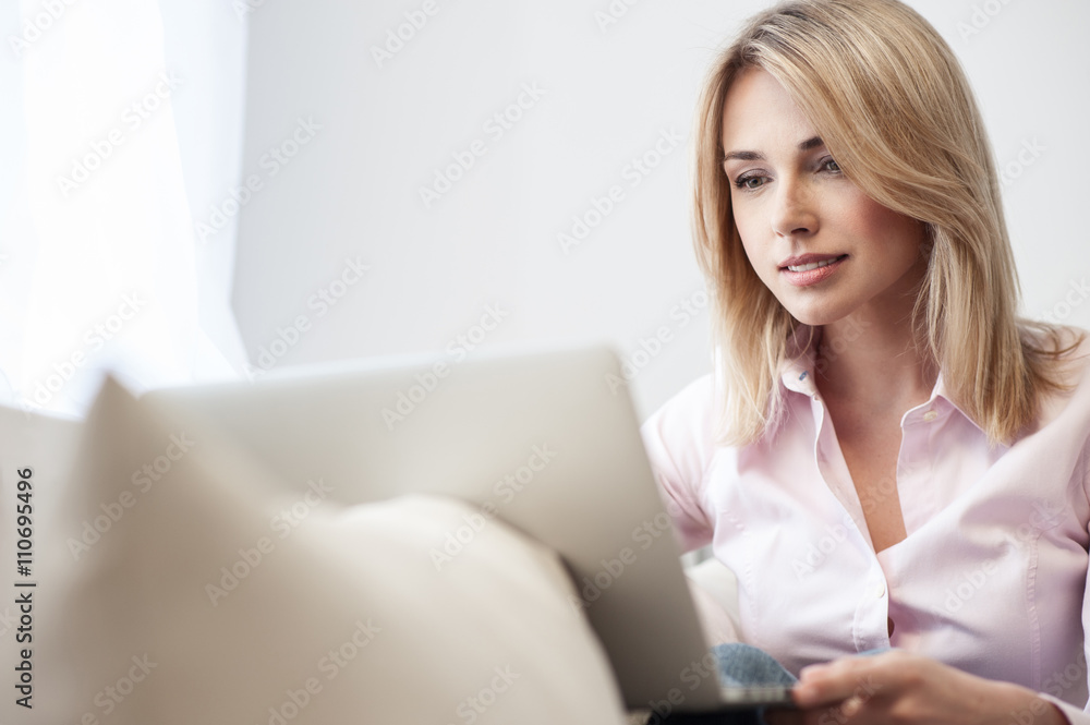 Cheerful blond girl is typing on a computer Cheerful blond girl is typing on a computer