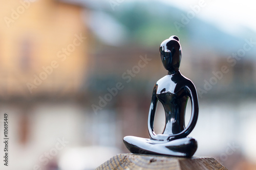 Silhouette of young girl doing yoga on blurred background photo