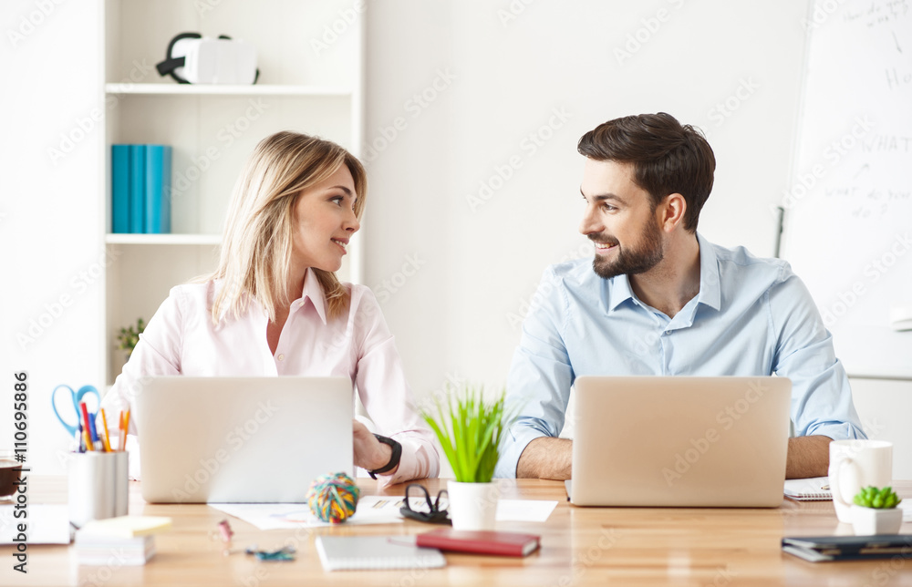 Cheerful two colleagues are working in cooperation Cheerful two colleagues are working in cooperation