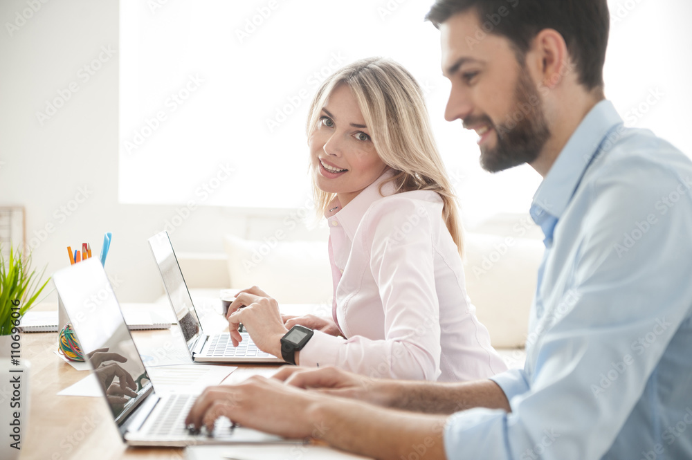 Cheerful young coworkers are using modern notebooks Cheerful young coworkers are using modern notebooks