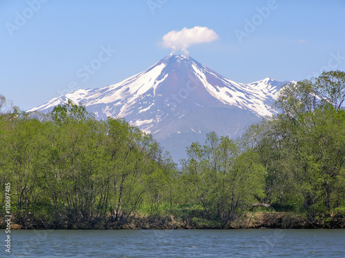 Kamchatka Volcano. summer.blue sky.Avachinsky Volcano.view of the Avachinsky Volcano from the shore of the river Avacha.from the crater of the volcano rises fumarole.
