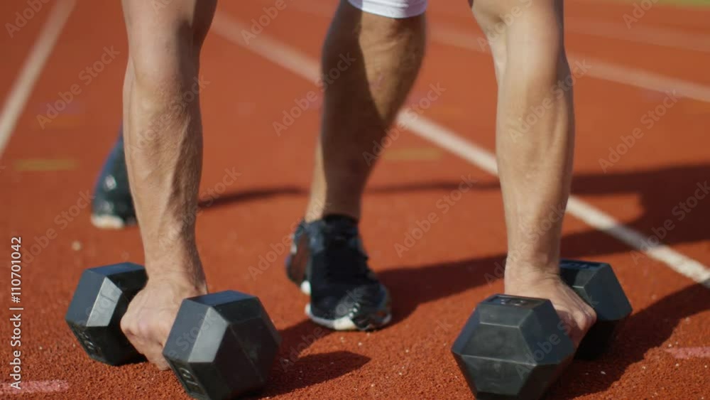 Disabled athlete with prosthetic leg working out with weights @ running track Disabled athlete with prosthetic leg working out with weights @ running track