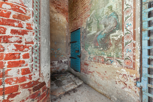 Old wooden blue door to the abandoned bell tower. Partially preserved ancient temple old Russian painting