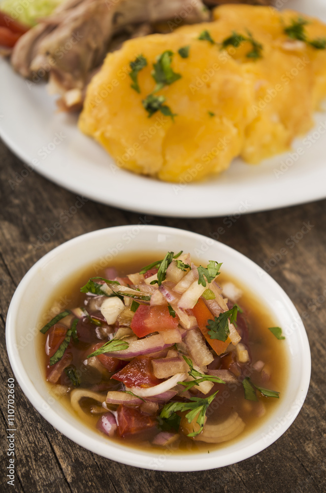 Delicious sliced potato pieces cooked to perfection, piled up on white plate with green herbal topping