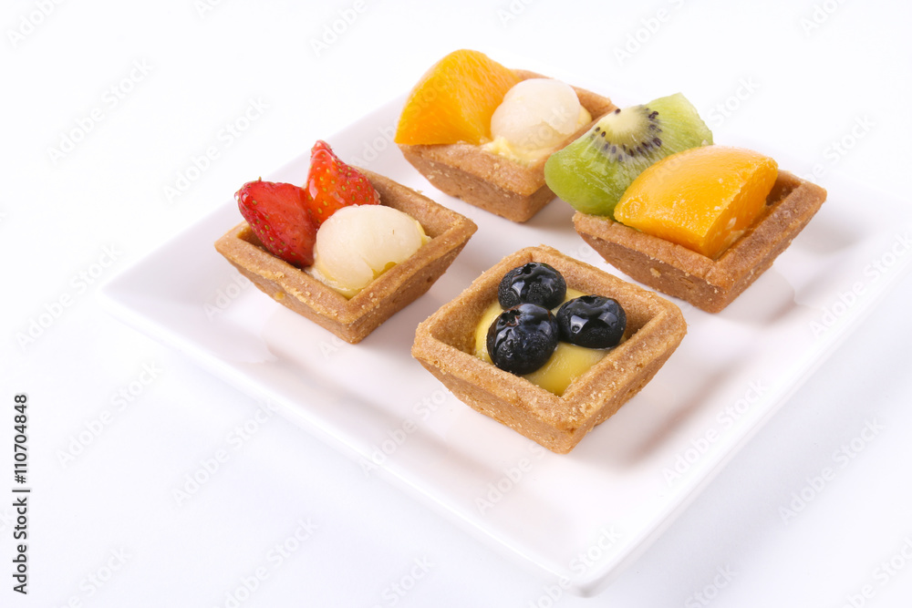 Assorted fruit tarts on square white plate