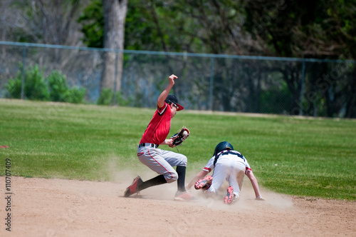 Obraz na płótnie Teenage baseball shortstop tagging player out at second base.