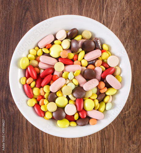 Colorful medical pills  tablets and capsules on plate  health care concept