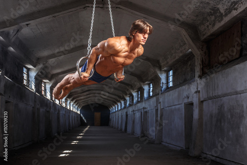 Canvas Print Man workouts in the air with gimnastic rings.