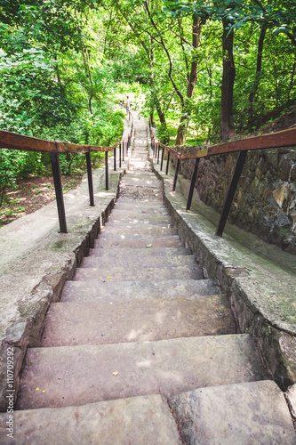 narrow stone staircase in summer park