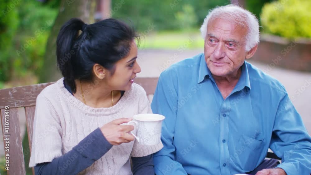 Caring home support worker with elderly man in the garden Caring home support worker with elderly man in the garden