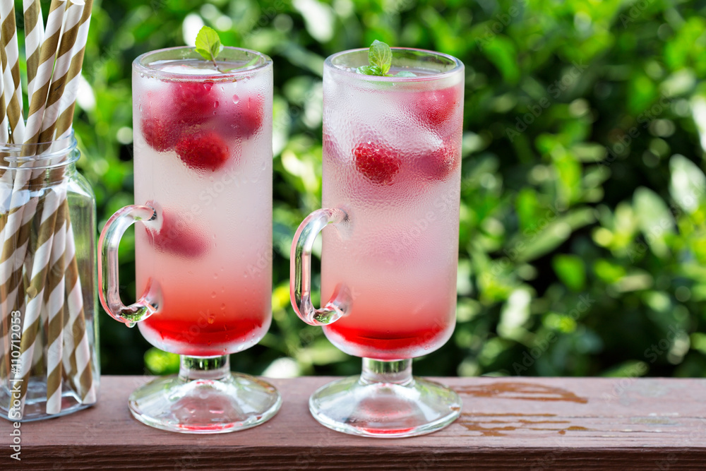 Pink raspberry lemonade in tall glasses Pink raspberry lemonade in tall glasses