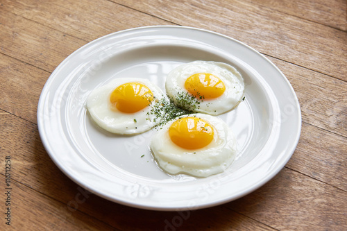 Fried eggs in plate on table