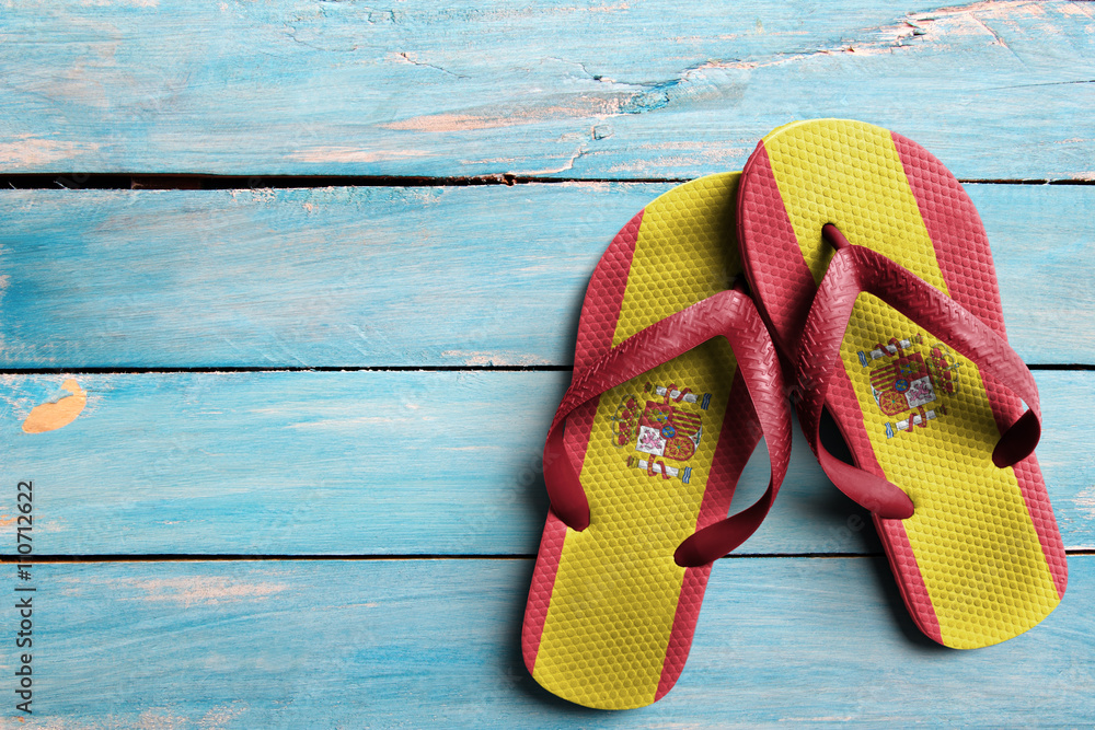 Thongs with flag of Spain, on blue wooden boards Stock Photo | Adobe Stock