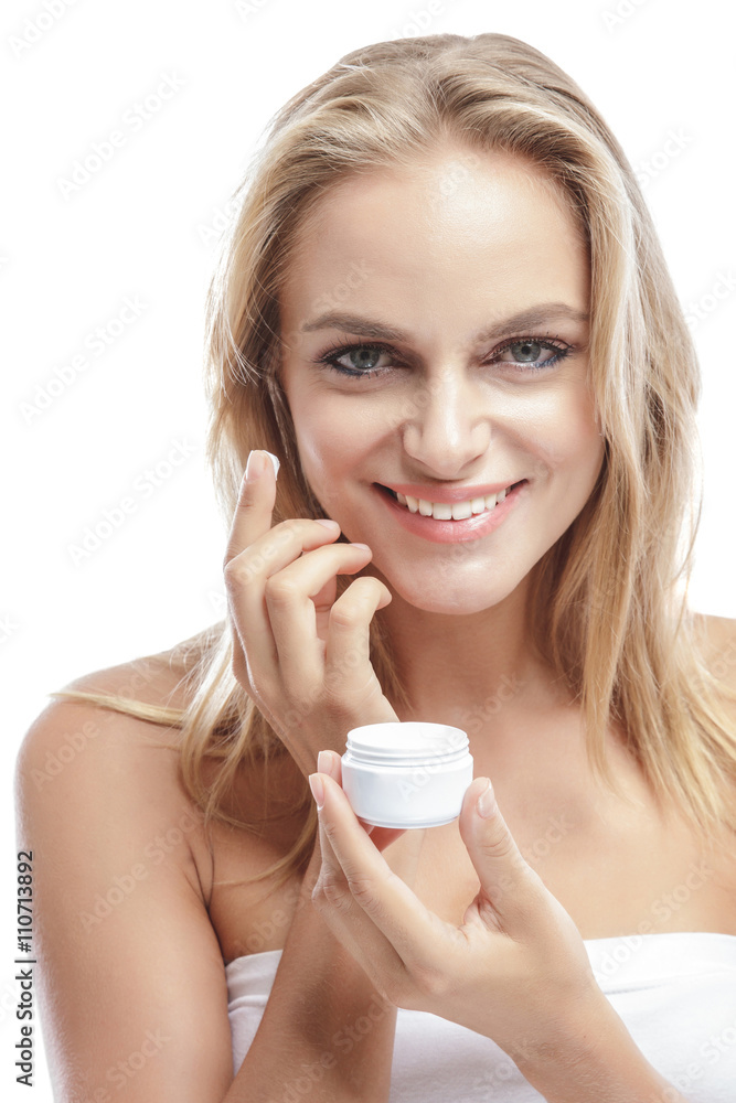 beautiful blonde woman applying some facial cream on her cheek beautiful blonde woman applying some facial cream on her cheek
