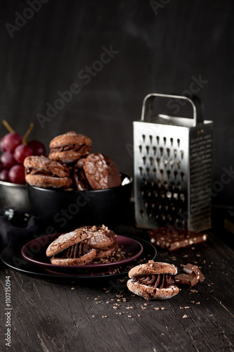 Almond cookies and grapes on dark wooden background photo