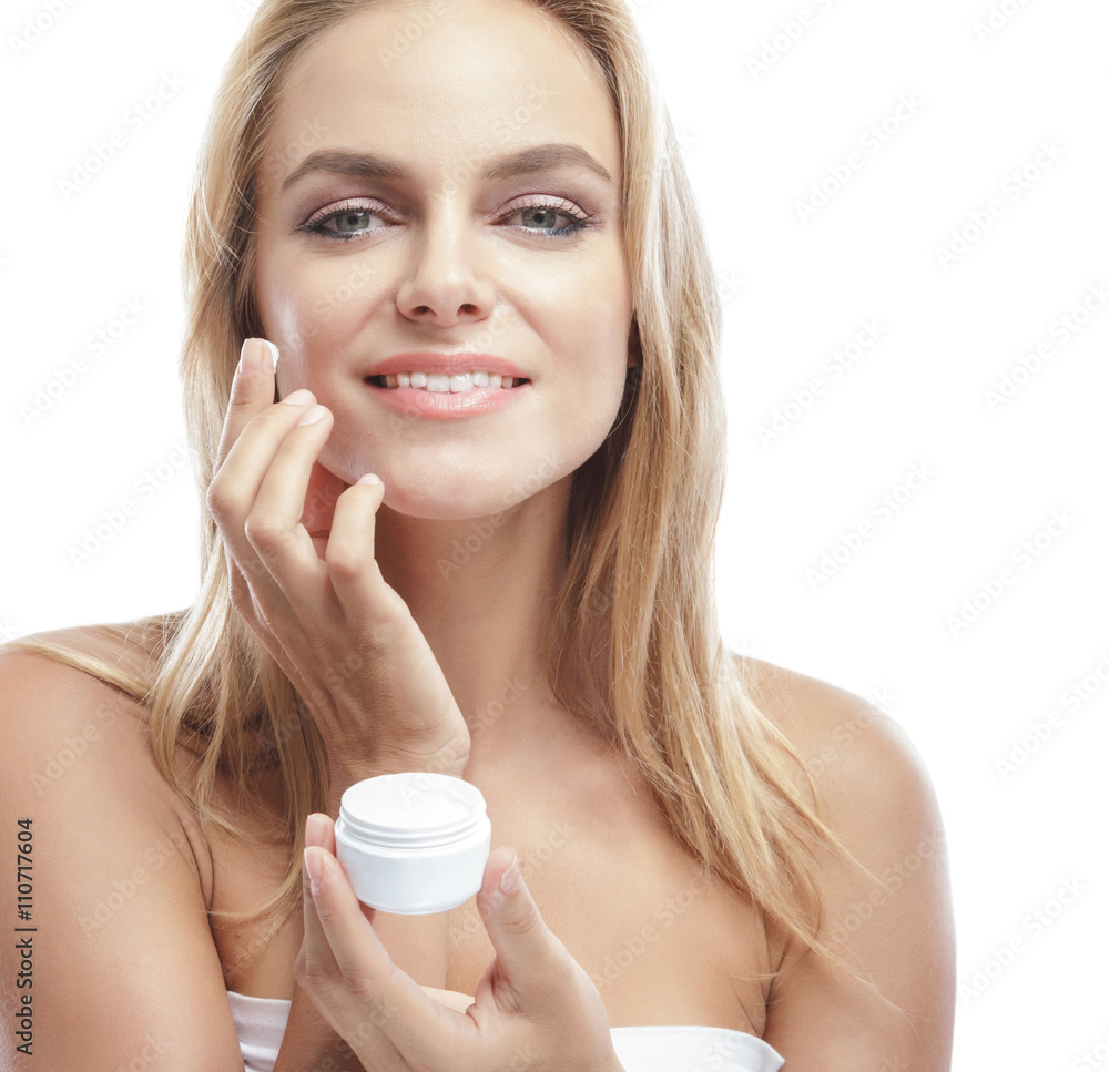 beautiful blonde woman applying some facial cream on her cheek beautiful blonde woman applying some facial cream on her cheek