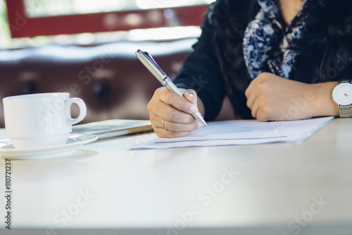 close up of business woman hand writing on a paperwork