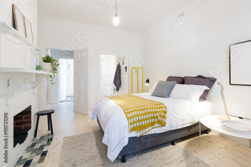 Obraz na płótnie Stylish contemporary bedroom with ensuite and yellow accents