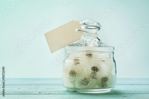 Fototapeta Naklejka Na Ścianę i Meble -  Blowball or dandelion in wishing jar with paper tag, vintage turquoise background, make a wish concept, unusual gift or present