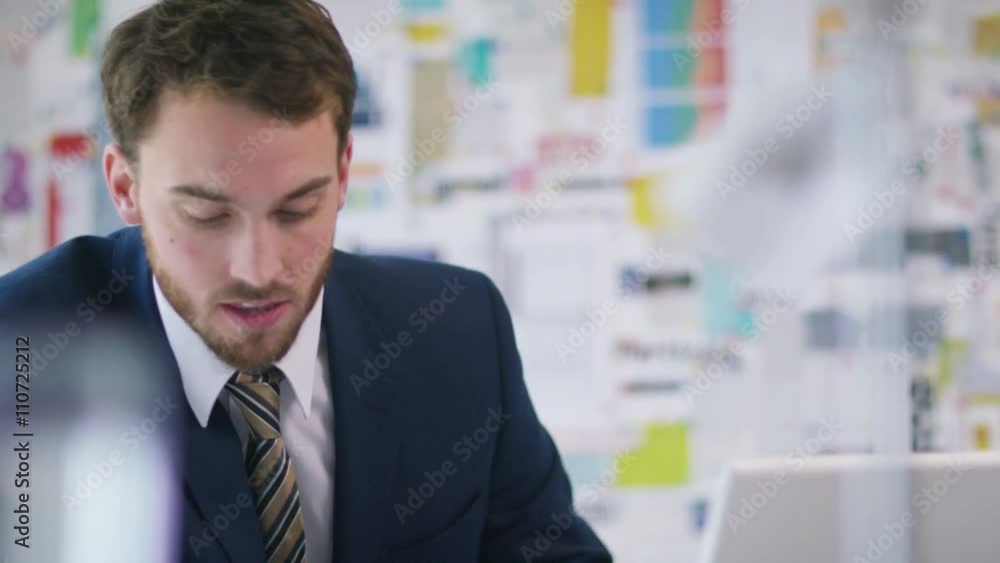 Cheerful businessman in office working on laptop computer Cheerful businessman in office working on laptop computer
