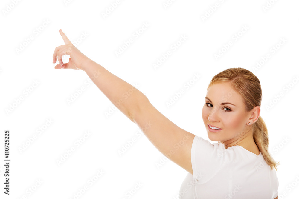 Young woman pointing on copy space or something Young woman pointing on copy space or something