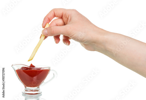 Female hand down french fries with ketchup in  cup isolated.