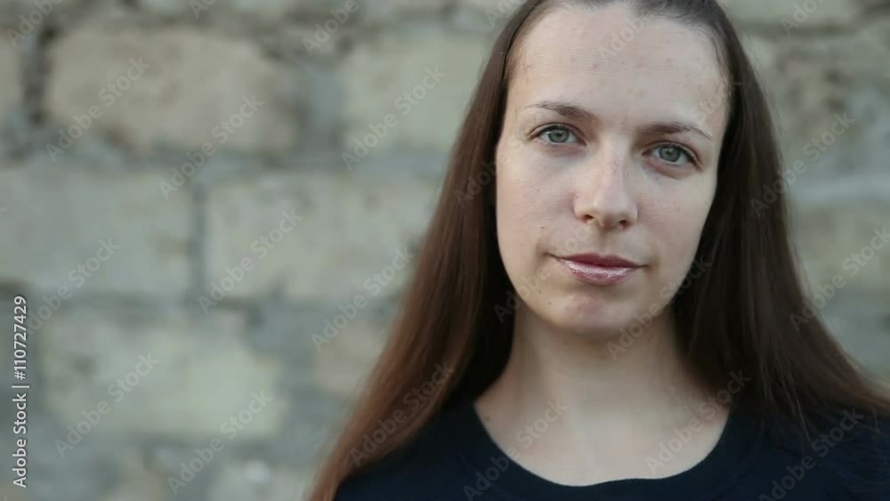 a beautiful girl standing at the concrete wall. Looking into the camera a beautiful girl standing at the concrete wall. Looking into the camera