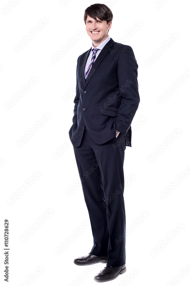 Elegant businessman stood with hands in pockets Elegant businessman stood with hands in pockets