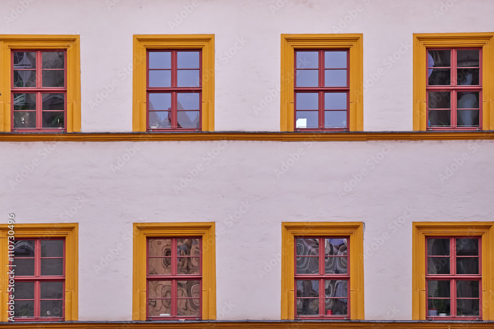 Fototapeta premium pale white building facade with orange framed windows