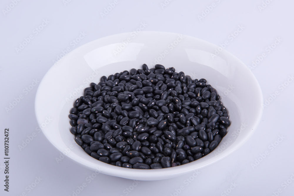 Black soybeans in white bowl on white background Black soybeans in white bowl on white background