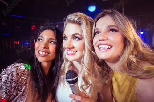  Happy friends singing at the karaoke in night club