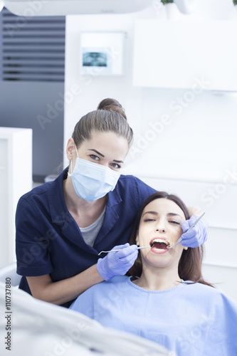 Beautiful woman patient having dental treatment at dentist s office. Women dentist