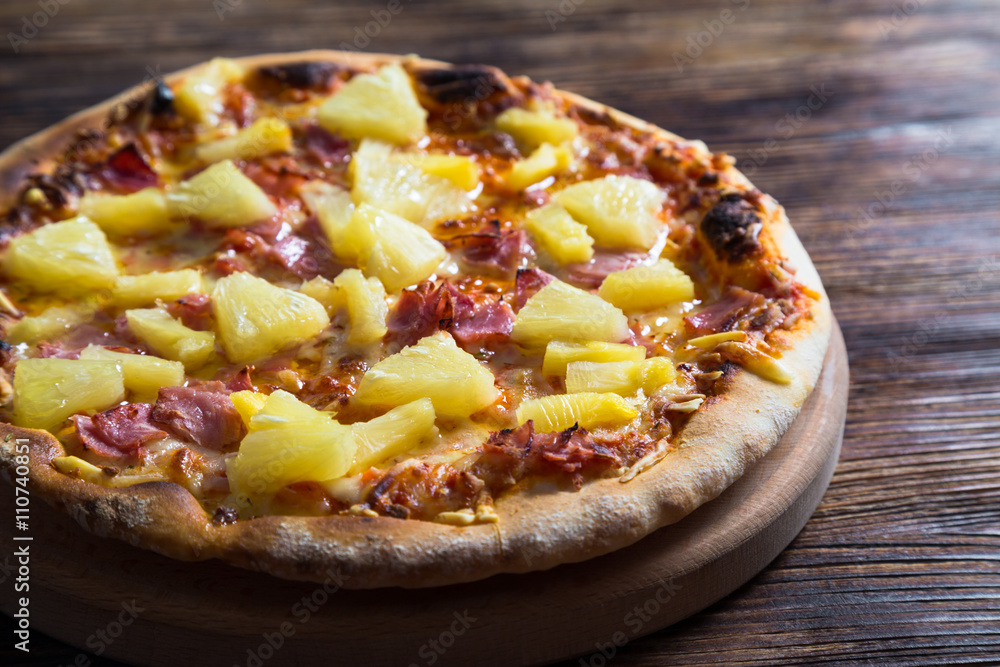Hawaiian pizza on a wooden table Hawaiian pizza on a wooden table