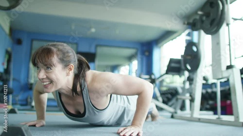  Woman working out at the gym and doing press ups photo