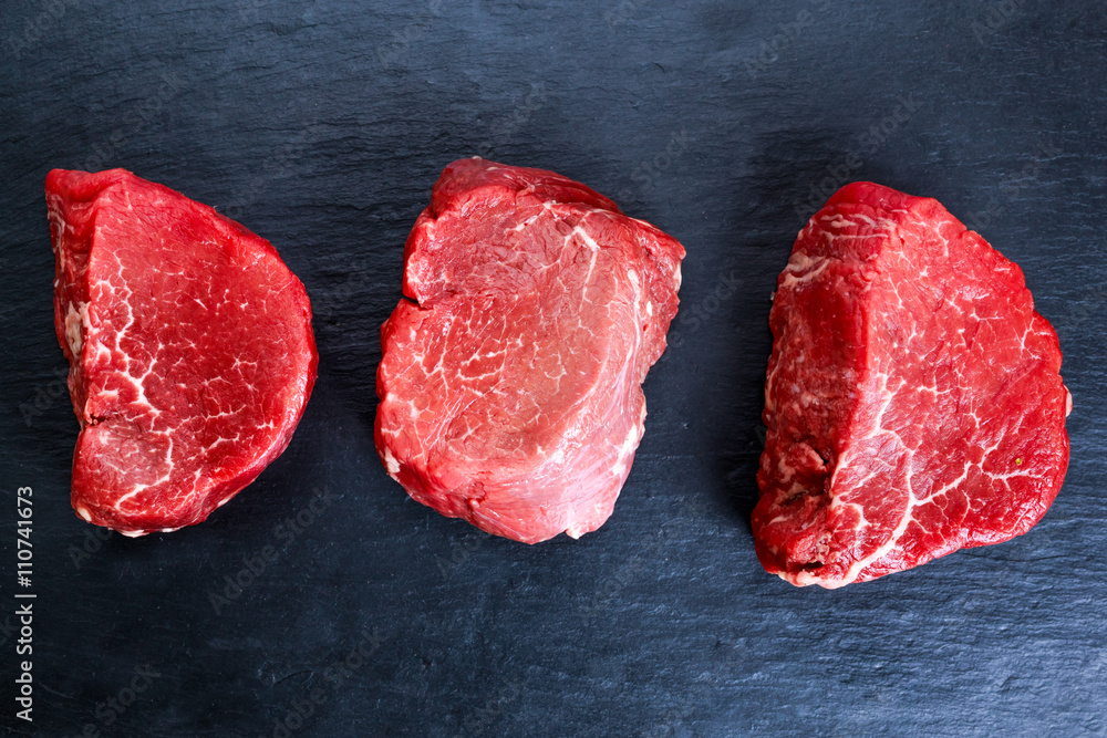 Fresh Raw Beef steak Mignon on blue dark board background,