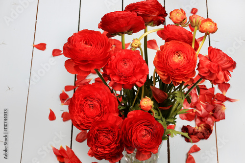 Ranunkulyus bouquet of red flowers on a wooden background greeting card photo