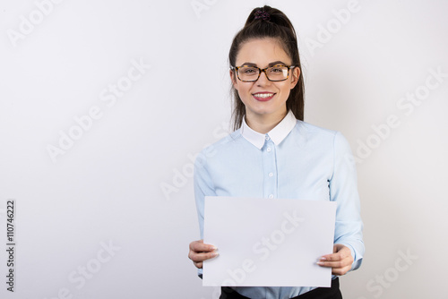 Młoda dziewczyna pokazuje informacje na białej kartce